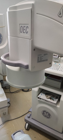 Arco cirúrgico móvel durante manutenção de equipamento médico em bancada técnica